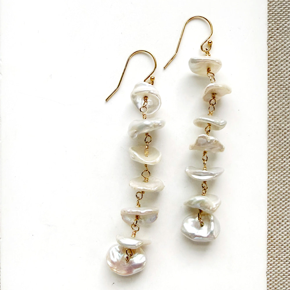Pearl drop earrings on a white card