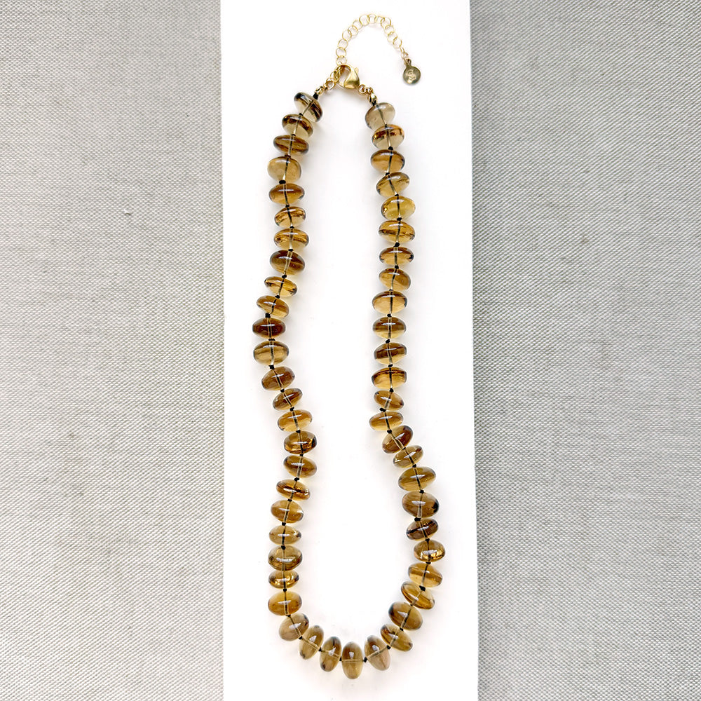 large whiskey quartz knotted necklace on a white plate