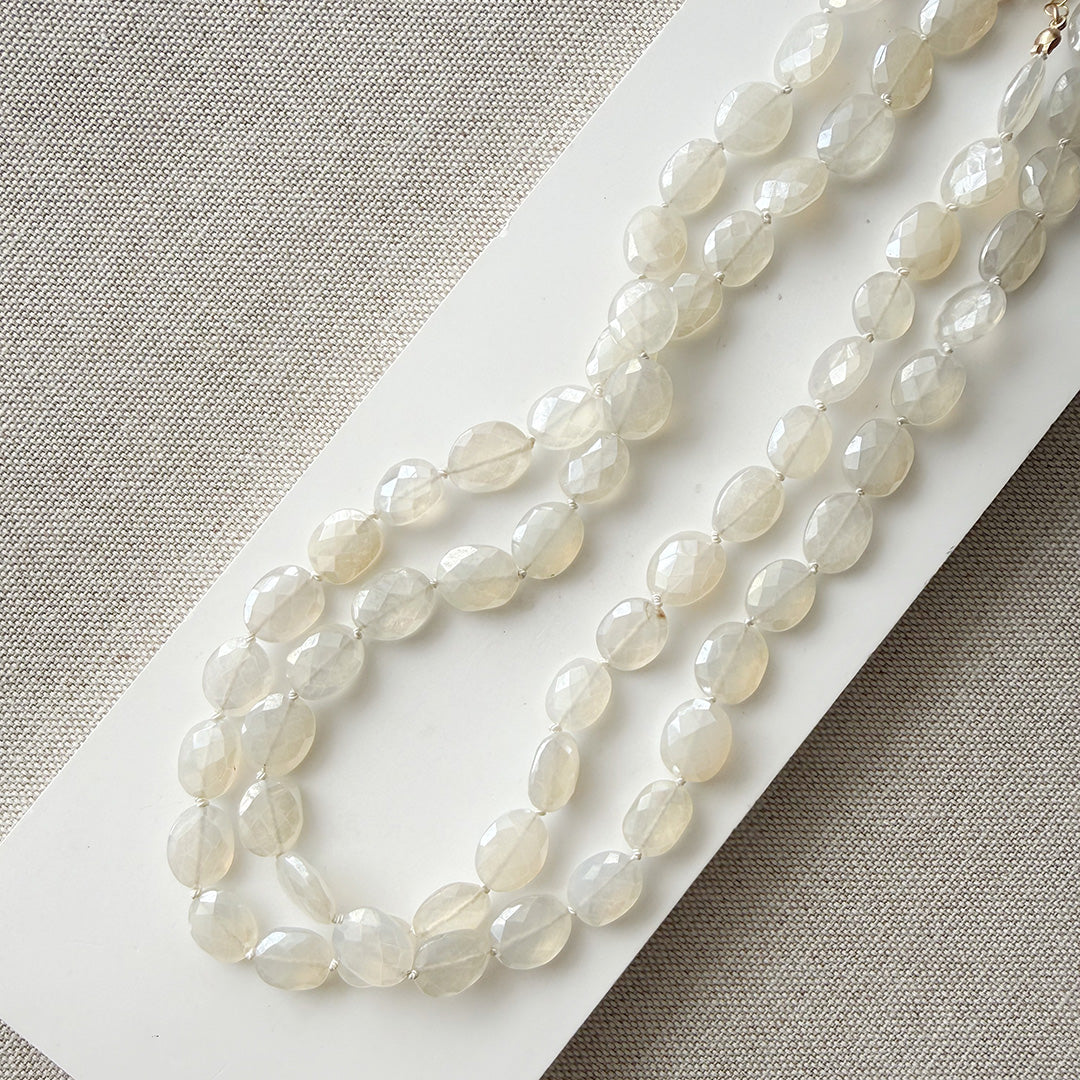 White chalcedony knotted necklace on a white card with a gray background