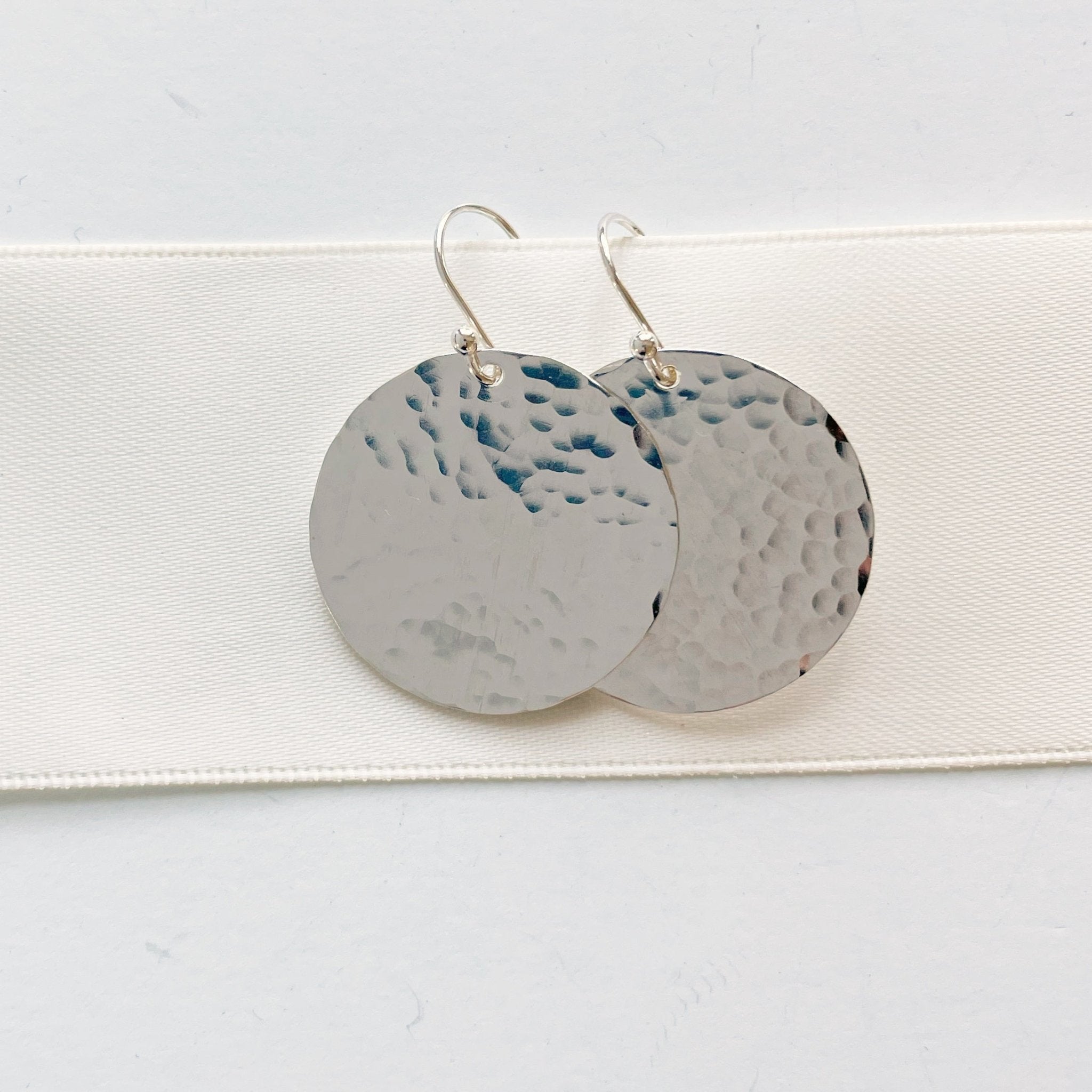 Silver Buffay Earrings by Sarah Cornwell Jewelry. Lightweight, shimmery, textured 1 inch silver disc earrings on a white background.