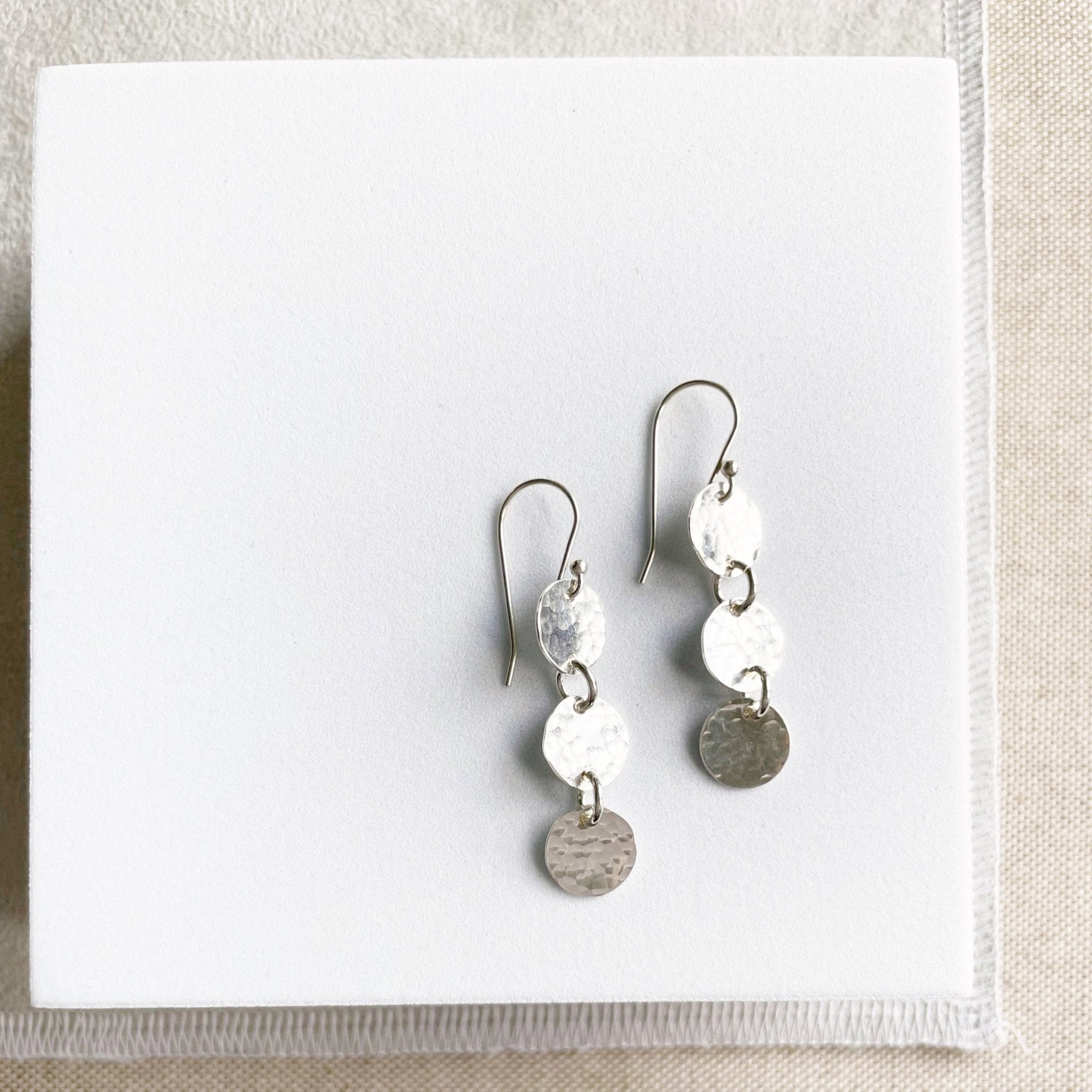 Silver 1.5 inch drop earrings with 3 same sized textured discs. Cole Earrings by Sarah Cornwell Jewelry