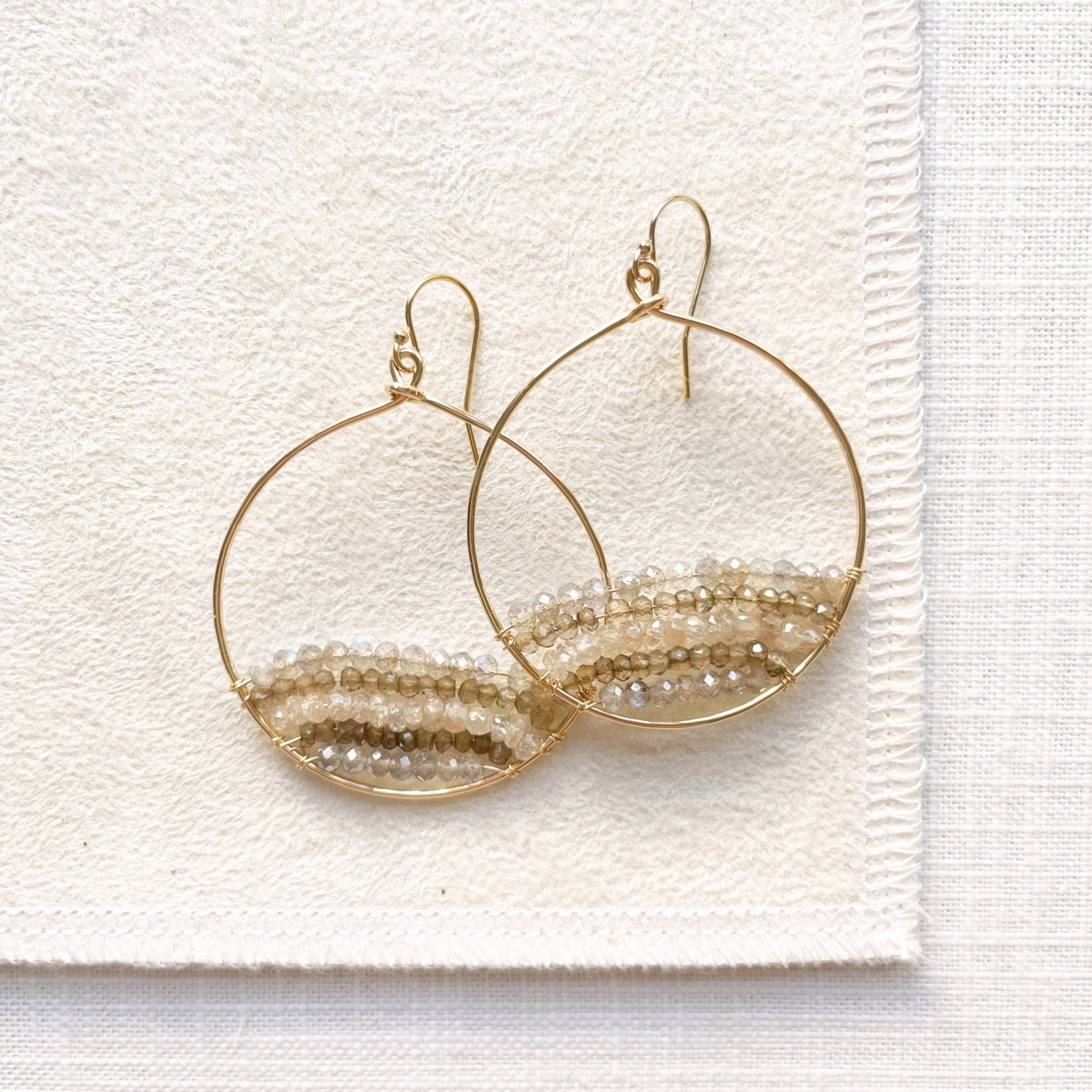 Gold and gemstone statement 2 inch hoop earrings with rows of zircon, labradorite, and smokey topaz gemstones. Harper Earrings by Sarah Cornwell Jewelry