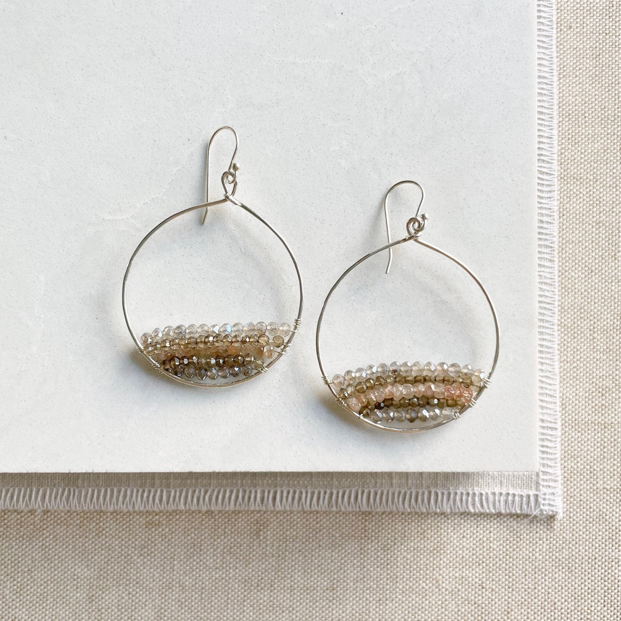 Silver and gemstone statement 2 inch hoop earrings with rows of zircon, labradorite, and smokey topaz gemstones. Harper Earrings by Sarah Cornwell Jewelry