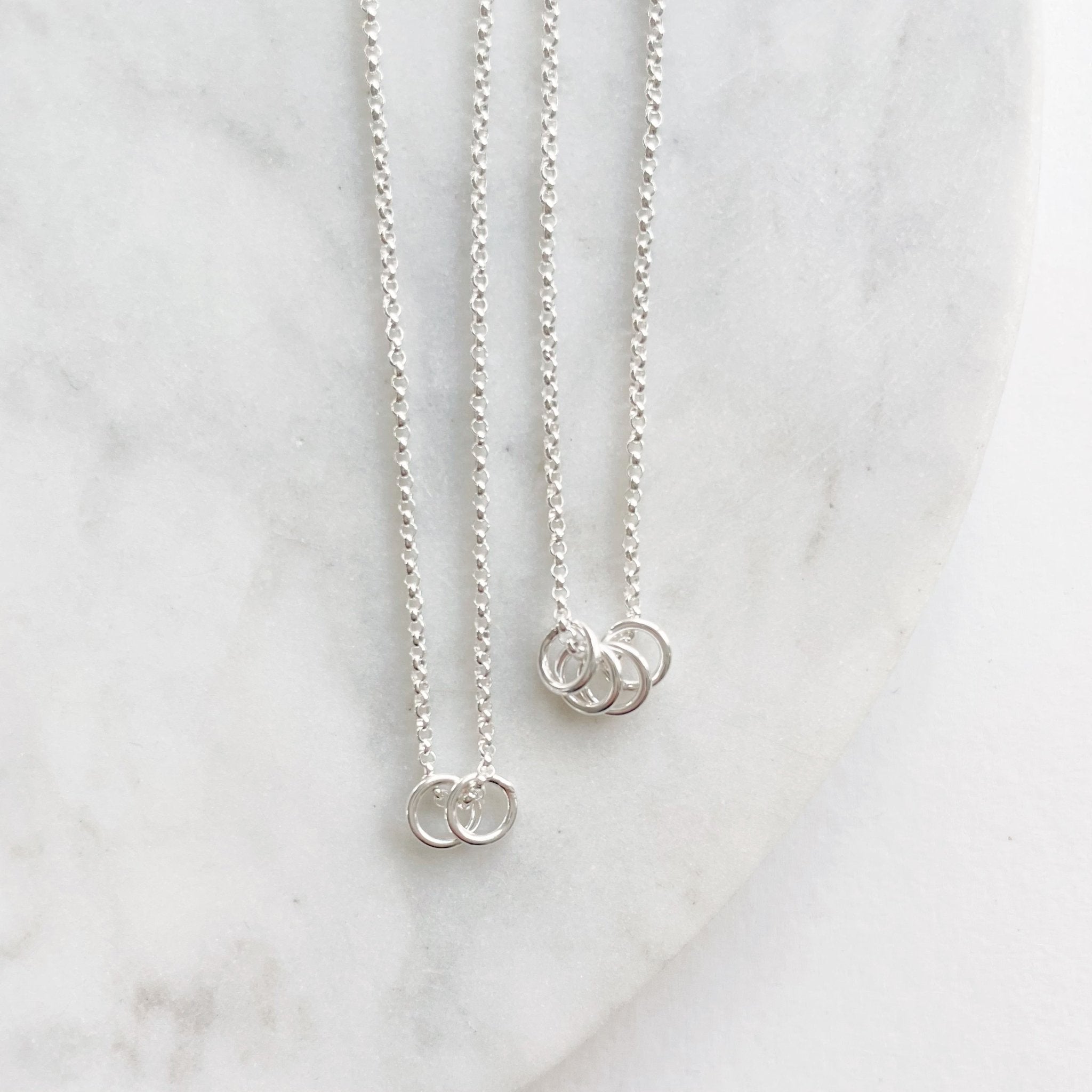 2 silver necklaces with 2 and 4 tiny silver rings. Honor Necklace by Sarah Cornwell Jewelry