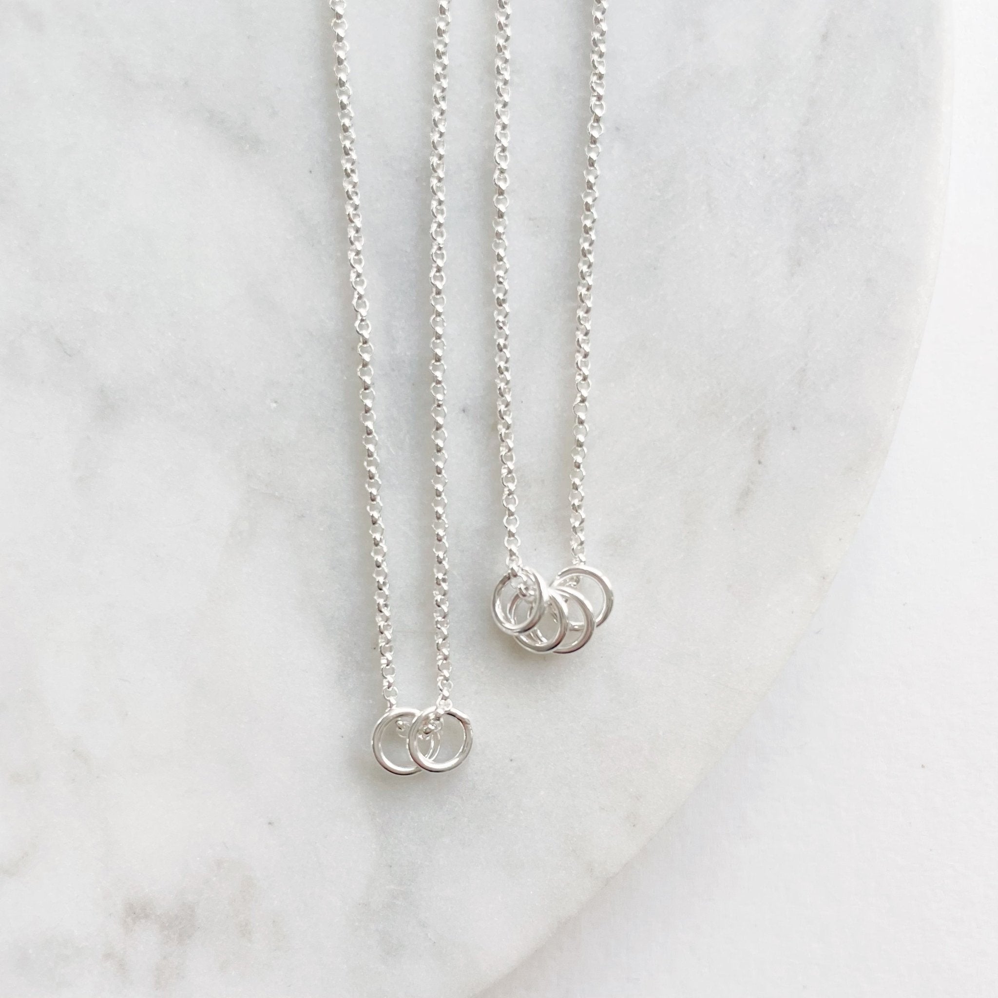 2 silver necklaces with 2 and 4 tiny silver rings. Honor Necklace by Sarah Cornwell Jewelry