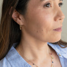 Woman wearing a colorful necklace with a neutral background