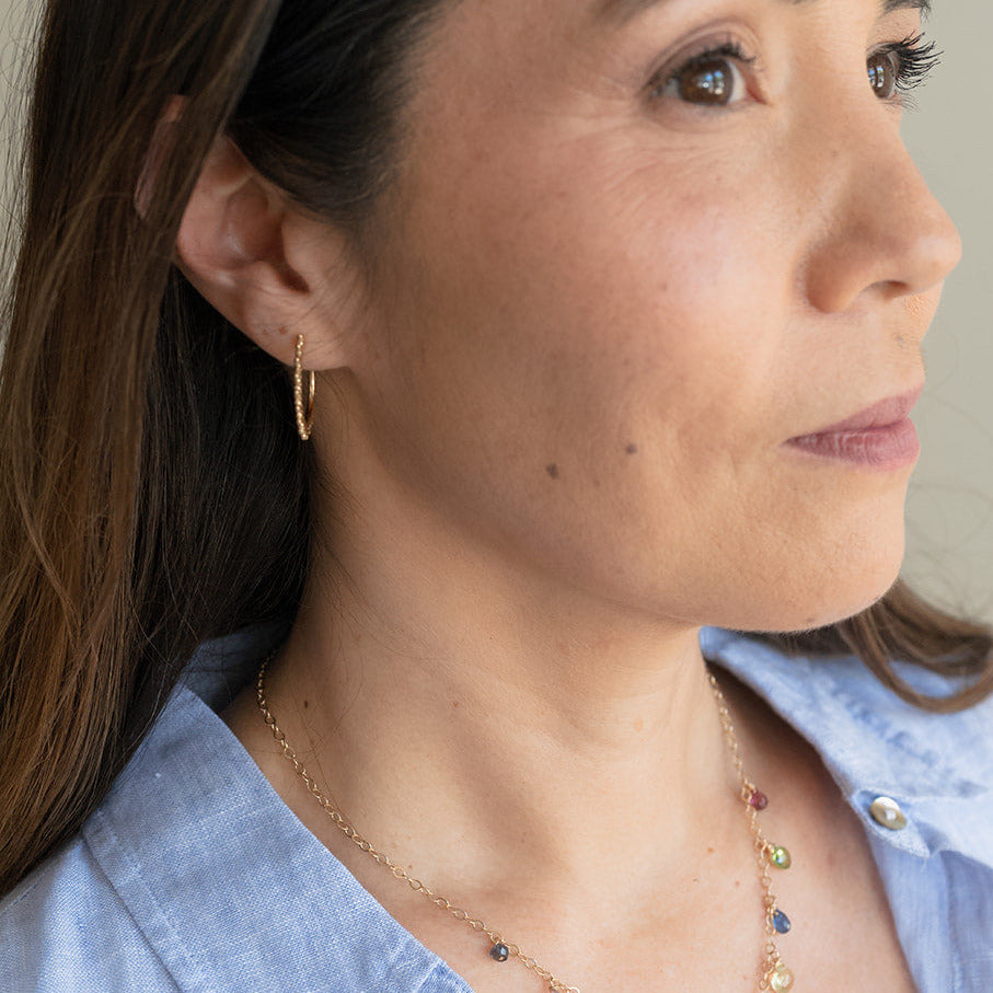 Woman wearing a colorful necklace with a neutral background