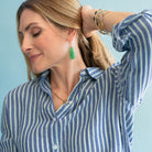 Woman wearing a blue and white striped shirt with a light blue background
