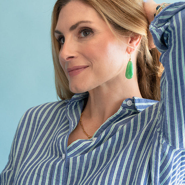Woman wearing a blue and white striped shirt against a light blue background