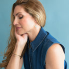 Woman wearing a blue denim vest against a light blue background