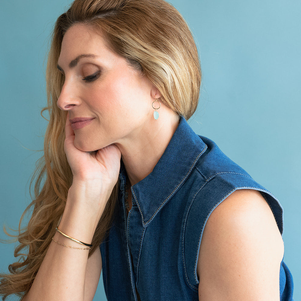 Woman wearing a blue denim vest against a light blue background