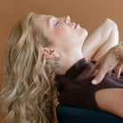 Woman wearing gemstone statement earring with labradorite and hessian garnet