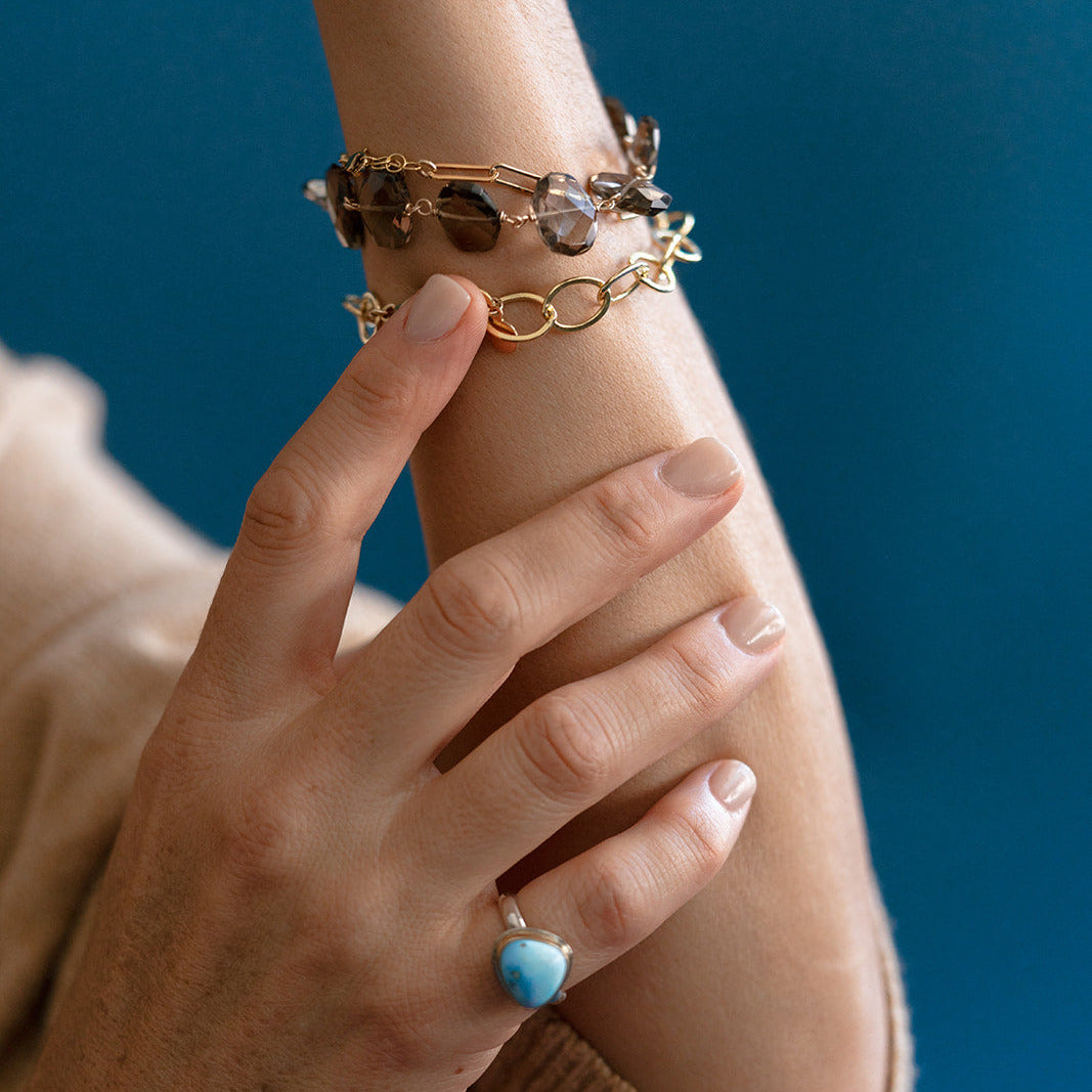 Woman wearing bracelet stack with smokey quartz gemstone bracelet