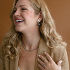Woman in camel colored jacket at peacock pearl earring
