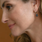 Woman wearing gold earring with kyanite stone drop