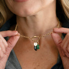Woman wearing gold chain with charm carabiner and mixed charms