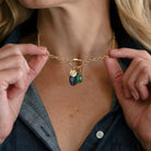 Woman holding chain with charm cluster