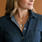 Woman wearing blue shirt and charm carabiner necklace