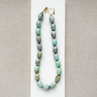 Necklace with teal agate beads on a white surface