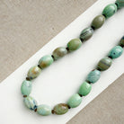 Necklace with teal agate beads on a white surface