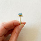 Side view of a smooth cushion cut mixed metal aquamarine ring