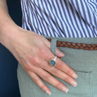 Hand wearing a smooth cushion cut mixed metal aquamarine ring 