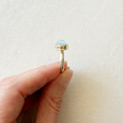 Side view of an oval aquamarine mixed metal ring 