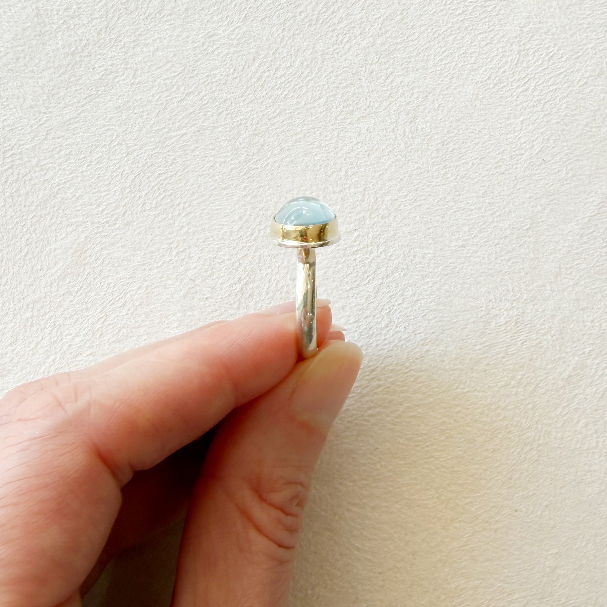 Side view of an oval aquamarine mixed metal ring 