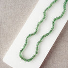Green Kyanite knotted necklace on a white dish with a neutral background