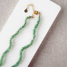 Green Kyanite knotted necklace on a white dish with a neutral background