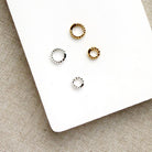 Charm ring enhancers in silver and gold on a white background