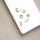 Charm ring enhancers in silver and gold on a white background