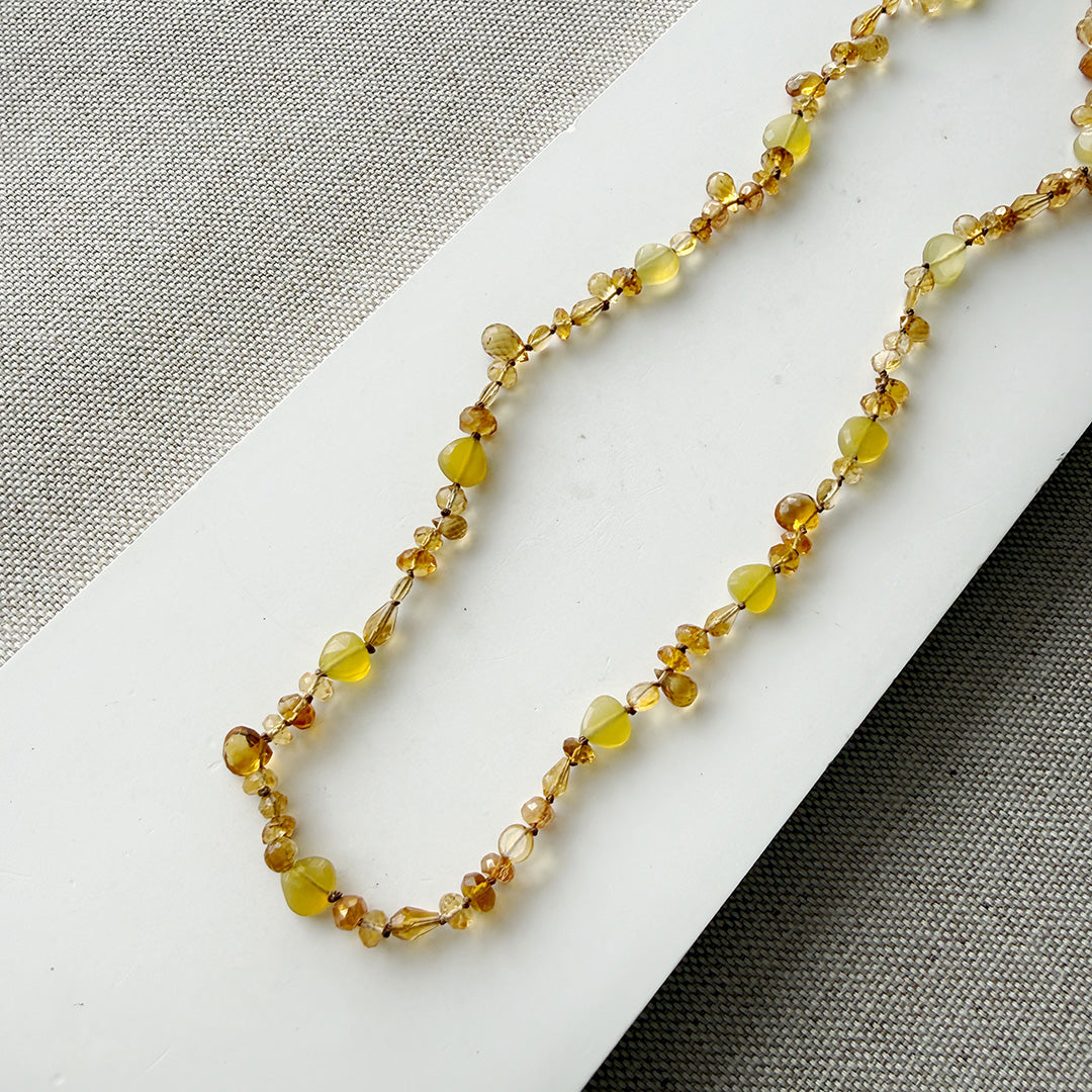 Citrine knotted gemstone necklace on a white surface