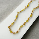 Citrine knotted gemstone necklace on a white surface