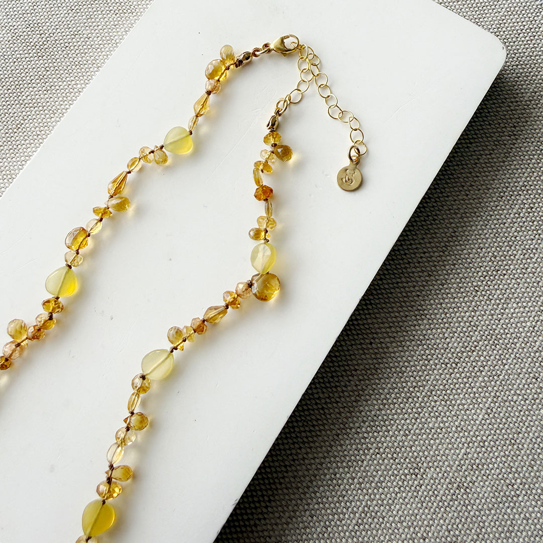 Clasp and extender of necklace with citrine gems on a white card