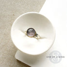 Round berry spinel ring in a mixed metal setting, placed in a white dish