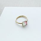 Gold ring with a rectangular gemstone on a white background