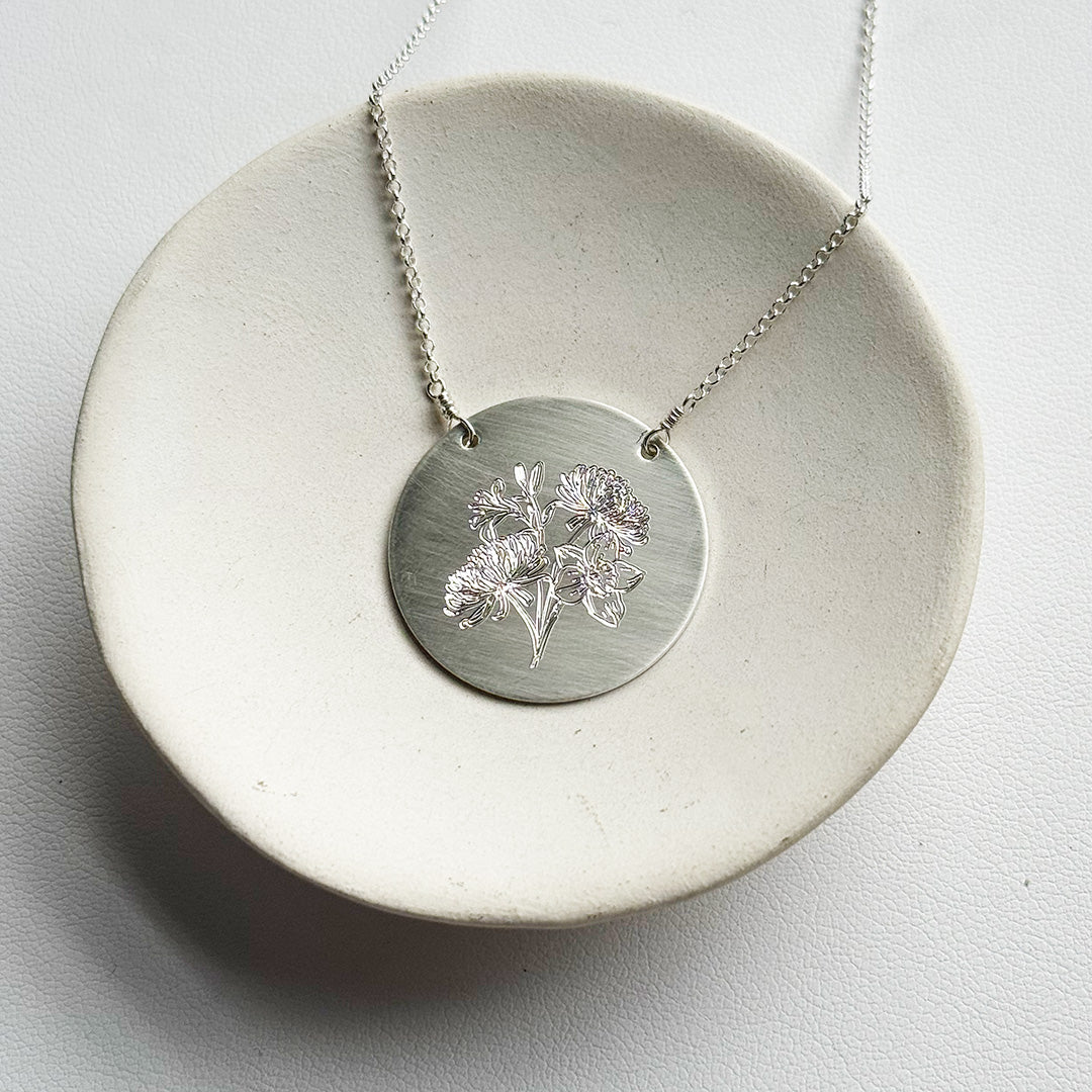 Silver pendant engraved with a floral bouquet