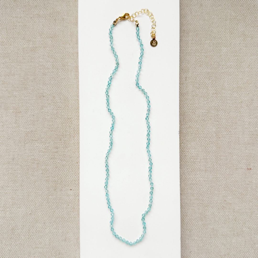 Bright blue apatite gemstone knotted necklace on a white background