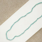 Bright blue apatite gemstone knotted necklace on a white background
