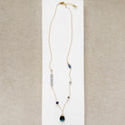 Gold necklace with mixed gems and pearls on a white background