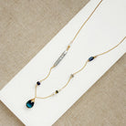 Gold necklace with mixed gems and pearls on a white background