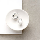 Chunky silver hoops in a white dish