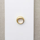 Gold ring on a light beige background