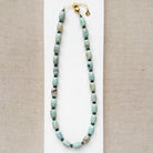 Necklace with teal agate beads on a beige background