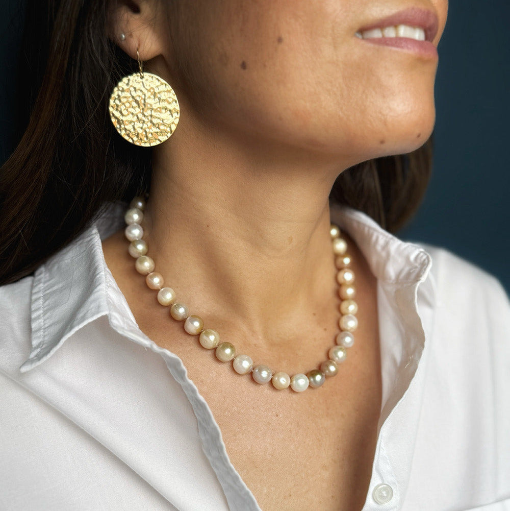 Woman wearing white shirt and a champagne pearl necklace