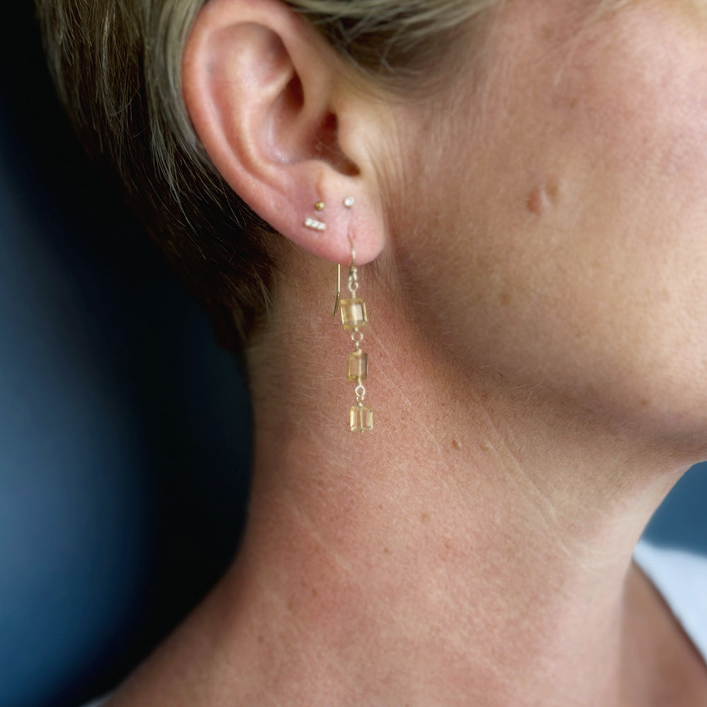 Close up of woman with short hair wearing a citrine gemstone earring