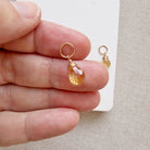 Hand holding a citrine teardrop shaped charm
