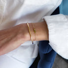 Gold bracelet on a wrist with a blurred background