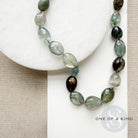 Copper aquamarine necklace on a white plate with one-of-a-kind label